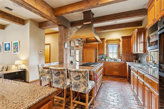 170 English Turn Dr, New Orleans, LA 70131 - kitchen featuring sink, a breakfast bar, island range hood, decorative backsplash, and stainless steel gas stovetop