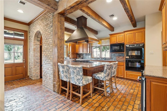 170 English Turn Dr, New Orleans, LA 70131 - kitchen with a breakfast bar, tasteful backsplash, beamed ceiling, island exhaust hood, and black appliances