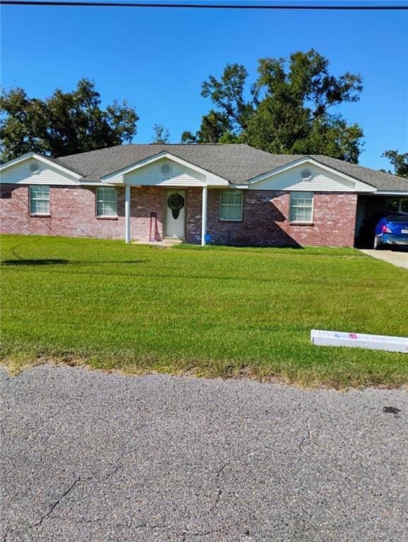 single story home featuring a front lawn and a carport