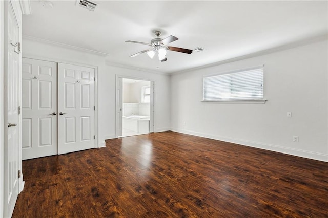 unfurnished bedroom featuring crown molding, ceiling fan, dark hardwood / wood-style floors, ensuite bathroom, and a closet