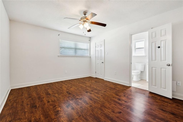 unfurnished bedroom featuring hardwood / wood-style flooring, a closet, ceiling fan, and ensuite bathroom