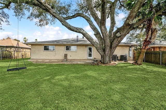 3512 James Dr, Metairie, LA 70003 - rear view of property featuring a lawn, brick siding, central AC, and a fenced backyard
