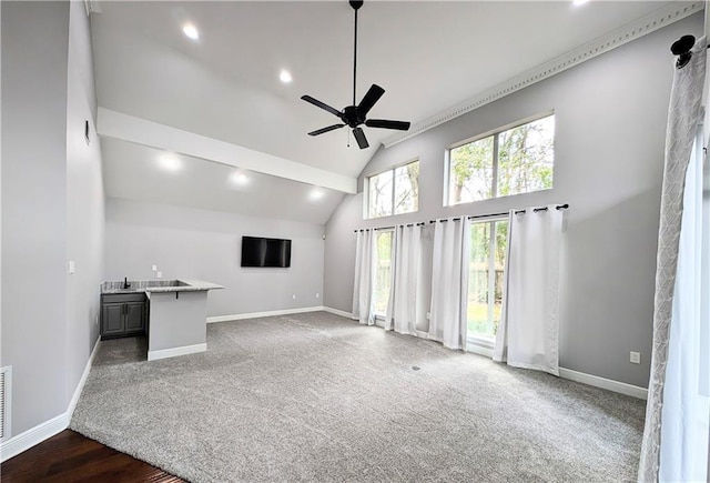 unfurnished living room featuring ceiling fan, dark carpet, and high vaulted ceiling