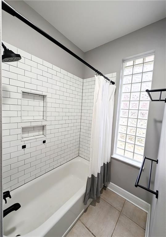 bathroom with tile patterned flooring and shower / bath combo with shower curtain