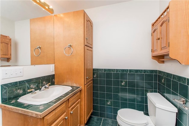 bathroom with vanity, toilet, tile patterned flooring, and tile walls