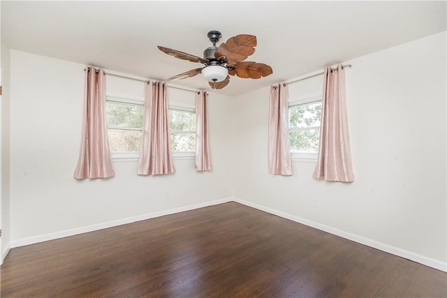 empty room featuring ceiling fan, plenty of natural light, and dark hardwood / wood-style flooring