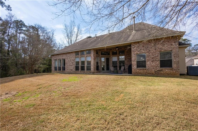 rear view of property featuring cooling unit and a lawn