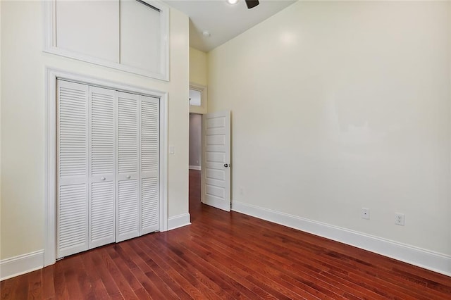 unfurnished bedroom featuring dark wood-type flooring and a closet