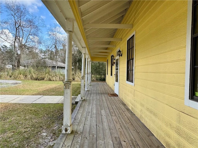 wooden terrace with a yard and a porch