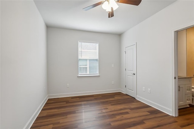 unfurnished bedroom featuring dark wood finished floors, baseboards, and ceiling fan