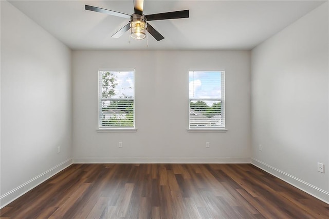 unfurnished room with a ceiling fan, plenty of natural light, baseboards, and dark wood-style flooring