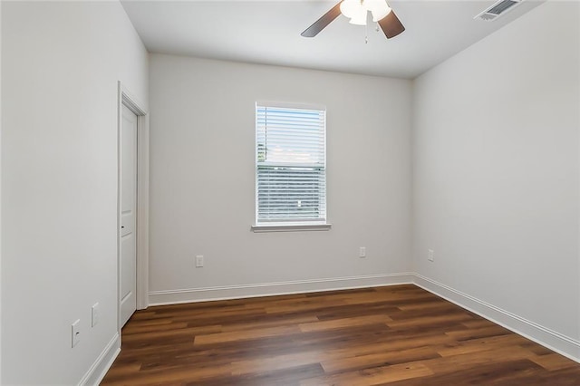 spare room featuring visible vents, a ceiling fan, baseboards, and wood finished floors