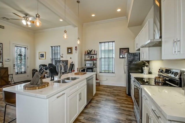 kitchen with stainless steel appliances, white cabinetry, a kitchen island with sink, and sink