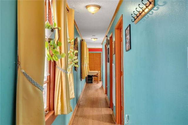 hallway featuring light hardwood / wood-style flooring and a textured ceiling