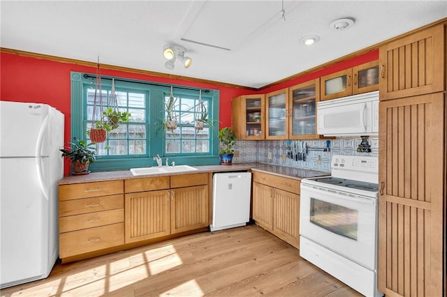 kitchen featuring sink, tasteful backsplash, hanging light fixtures, light hardwood / wood-style flooring, and white appliances