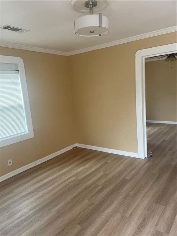 spare room featuring hardwood / wood-style flooring and ornamental molding