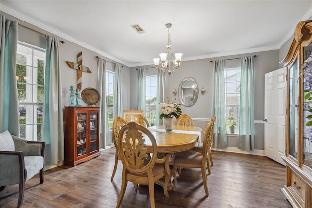 dining space with crown molding, a wealth of natural light, and dark hardwood / wood-style flooring