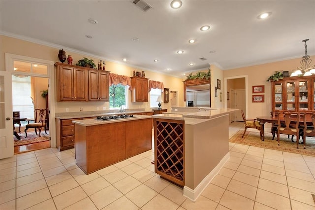 kitchen featuring hanging light fixtures, light tile patterned floors, a center island, and appliances with stainless steel finishes