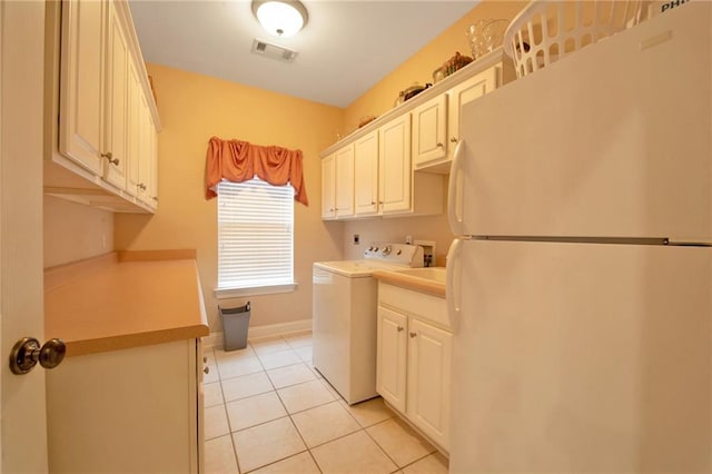 clothes washing area featuring light tile patterned flooring, cabinets, and washer / dryer