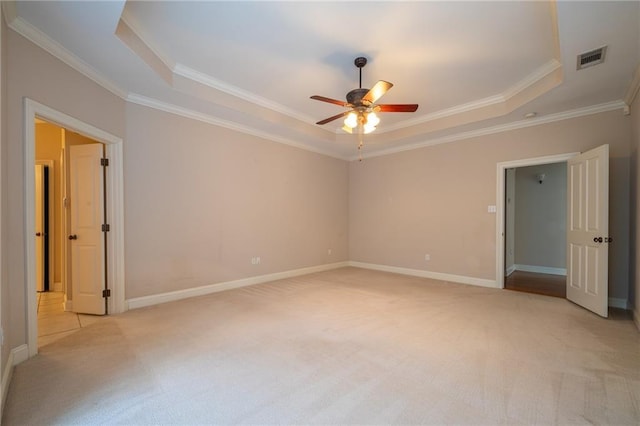 unfurnished bedroom featuring light carpet and a tray ceiling