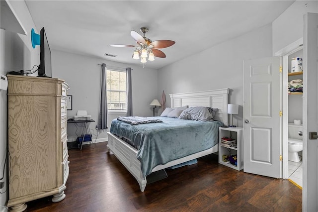 bedroom with connected bathroom, dark wood-type flooring, and ceiling fan