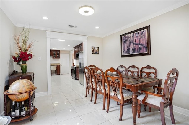 dining room with light tile patterned floors and ornamental molding