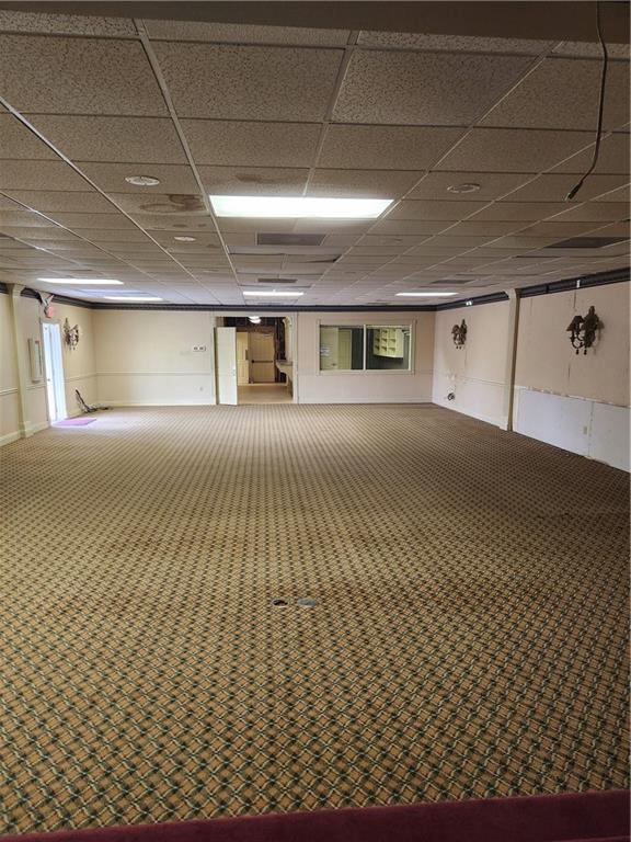 basement featuring a paneled ceiling and carpet