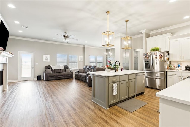 kitchen with pendant lighting, white cabinetry, a kitchen island with sink, stainless steel appliances, and light wood-type flooring