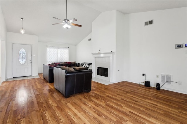 living room featuring hardwood / wood-style flooring, high vaulted ceiling, and ceiling fan