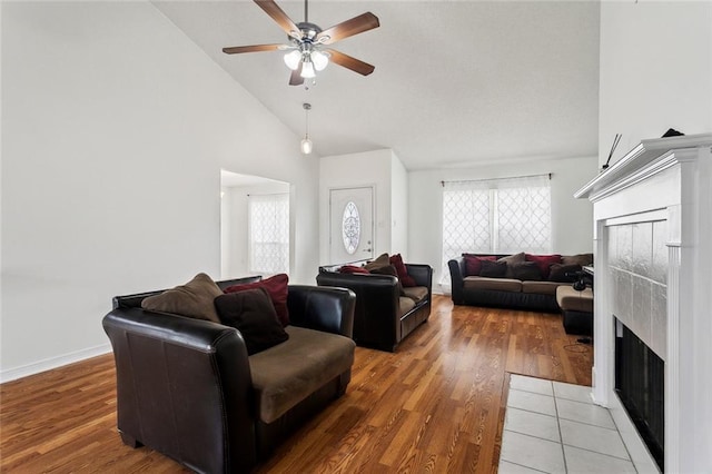 living room featuring hardwood / wood-style flooring, ceiling fan, high vaulted ceiling, and a wealth of natural light