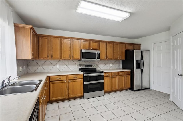 kitchen featuring stainless steel appliances, sink, decorative backsplash, and light tile patterned floors