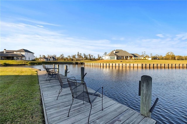 dock area with a yard and a water view