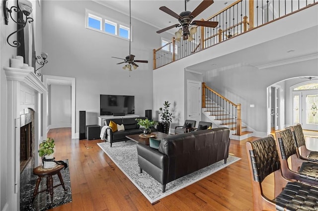 living room with crown molding, a wealth of natural light, and light wood-type flooring