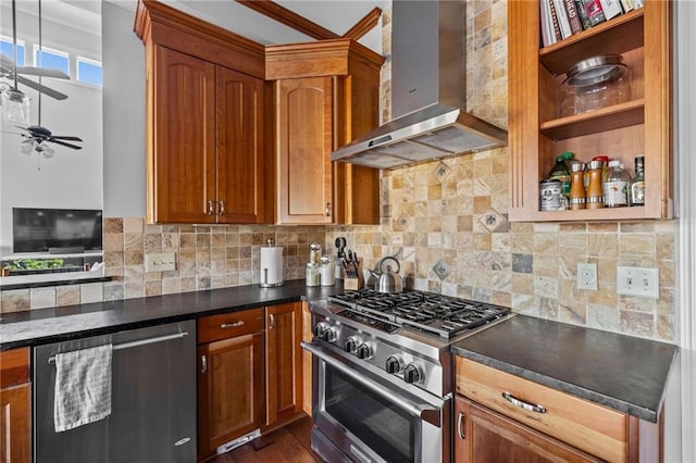 kitchen with wall chimney range hood, dark hardwood / wood-style flooring, ceiling fan, stainless steel appliances, and backsplash