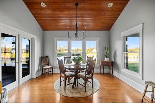 dining space with vaulted ceiling, a healthy amount of sunlight, and light wood-type flooring