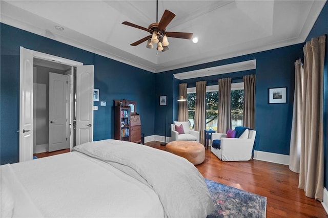 bedroom featuring crown molding, ceiling fan, dark hardwood / wood-style floors, and a raised ceiling