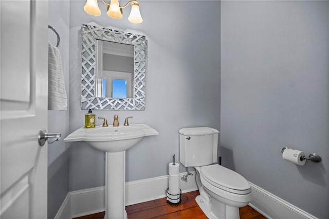bathroom featuring an inviting chandelier, sink, toilet, and hardwood / wood-style floors