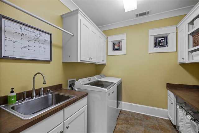 laundry area featuring cabinets, sink, and washing machine and clothes dryer