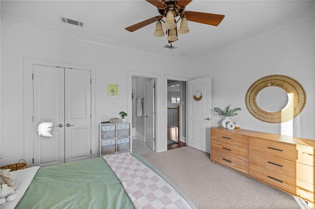 carpeted bedroom with crown molding, ceiling fan, and a closet