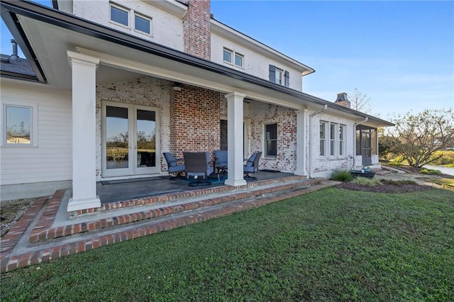 rear view of house with french doors, a yard, and a patio area