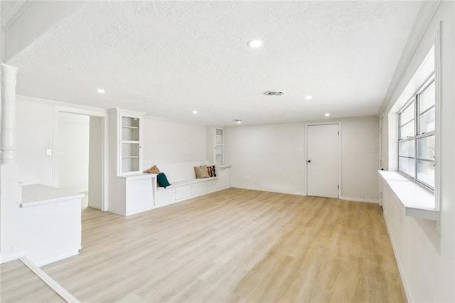 interior space featuring a textured ceiling and light hardwood / wood-style floors