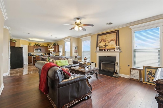 living room with ornamental molding, ceiling fan, and dark hardwood / wood-style flooring