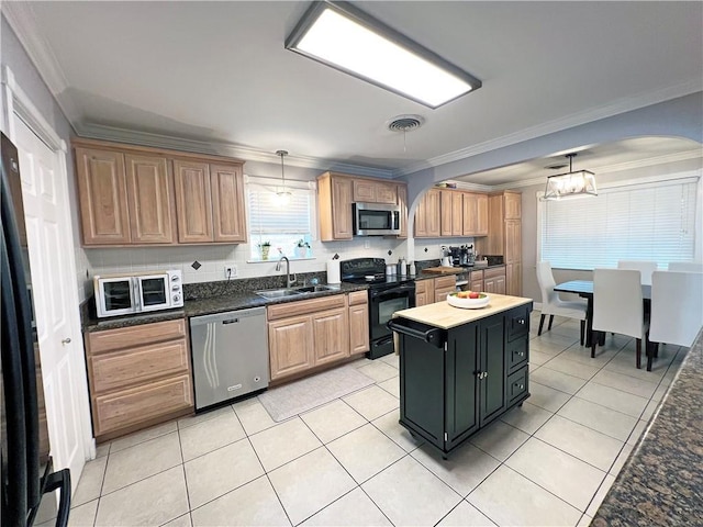 kitchen with light tile patterned floors, sink, hanging light fixtures, black appliances, and decorative backsplash