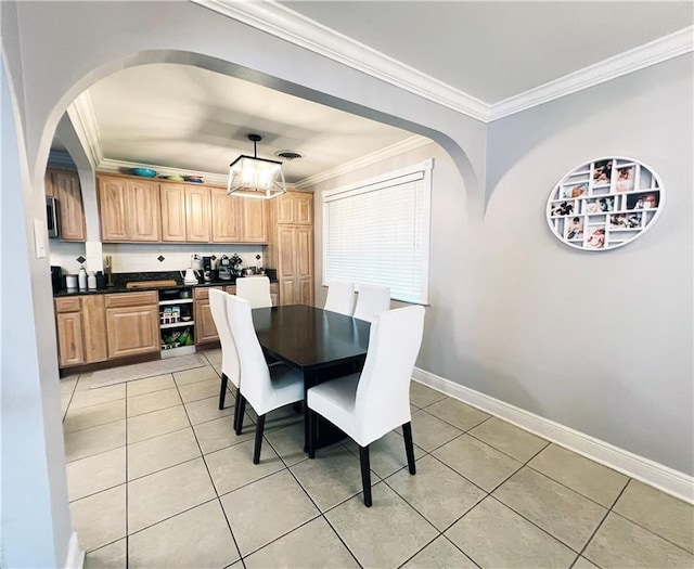 dining area featuring ornamental molding and light tile patterned floors