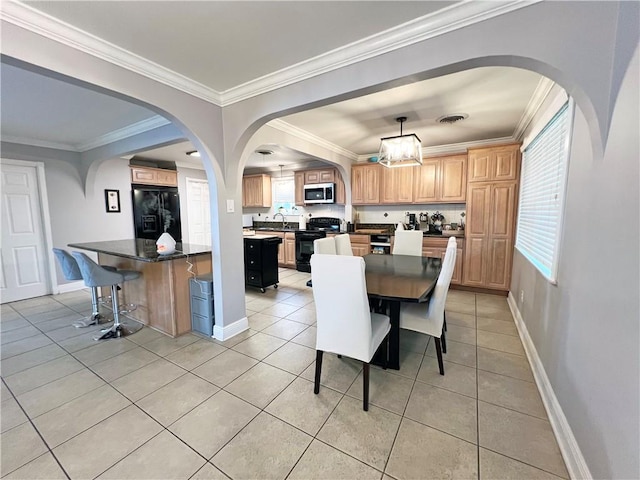 tiled dining space with crown molding and sink