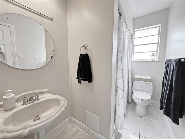 bathroom with tile patterned flooring, sink, and toilet