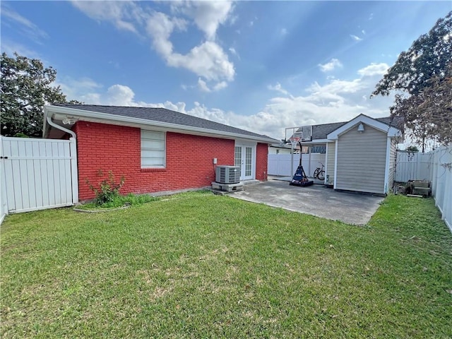 back of property featuring central AC unit, a yard, a patio, and french doors