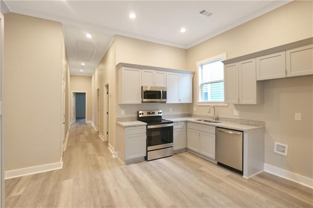 3533 S Liberty St, New Orleans, LA 70115 - kitchen with appliances with stainless steel finishes, light wood finished floors, light stone counters, recessed lighting, and gray cabinetry