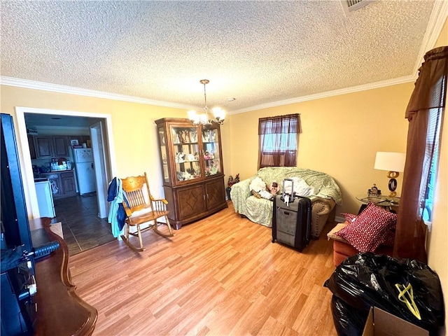 living room featuring crown molding, wood-type flooring, a textured ceiling, and a chandelier