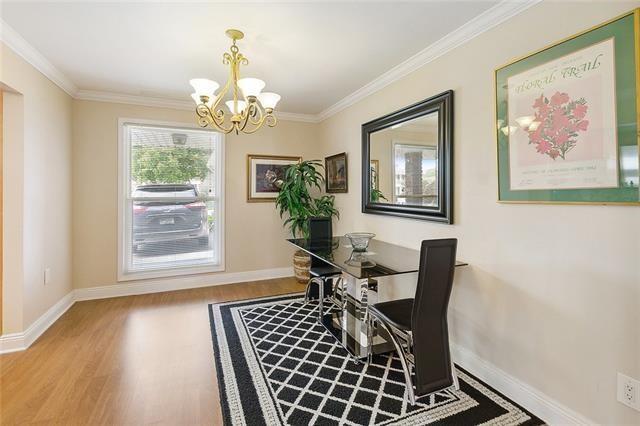 dining room with crown molding, a chandelier, and light hardwood / wood-style flooring